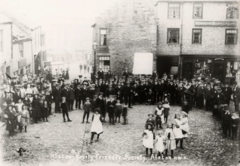Children And Band In Cobbled Village Square Alston